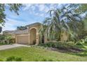 Charming single-story home boasts a manicured lawn, arched entryway, and attached two-car garage at 215 Foxglove Way, Deland, FL 32724