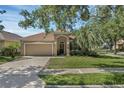 Charming single-story home boasts a manicured lawn, arched entryway, and attached two-car garage at 215 Foxglove Way, Deland, FL 32724