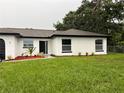 Well-manicured lawn, modern landscaping, and freshly painted home with a black front door at 3 Spur Ct, Kissimmee, FL 34743