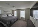 Bedroom with large windows, carpet flooring, and a TV on the wall at 3012 Mahalo Dr, Davenport, FL 33897