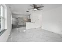 Open concept living space showcasing tile floors, a ceiling fan, with a view to the adjacent, modern kitchen at 306 Modest St, Lakeland, FL 33805