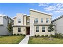 Modern two-story home with a unique architectural style, manicured lawn, and a vibrant red front door at 4185 Paragraph Dr, Kissimmee, FL 34746