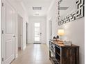 Bright hallway with tile flooring, a modern console table with lamp, and decorative mirror at 4185 Paragraph Dr, Kissimmee, FL 34746