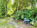 Secluded backyard garden area with a charming patio set surrounded by lush greenery and mature trees at 660 Neile Ct, Oviedo, FL 32765