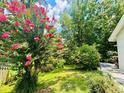 Lush backyard garden with flowering trees, mature landscaping, and a well-maintained lawn at 660 Neile Ct, Oviedo, FL 32765