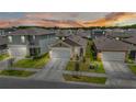 Scenic aerial shot of a residential neighborhood at sunset with manicured lawns at 7112 Mottled Duck Dr, Harmony, FL 34773