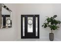 Elegant foyer featuring a decorative glass front door, a large mirror, and a potted plant at 800 Hamilton Place Ct, Winter Park, FL 32789
