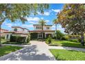 Charming two-story home featuring lush landscaping, a tiled roof, and a paved driveway at 800 Hamilton Place Ct, Winter Park, FL 32789
