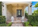 Elegant front porch with stone accents, decorative lion statues, and stylish lighting fixtures at 800 Hamilton Place Ct, Winter Park, FL 32789