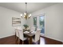 Elegant dining room features a wooden table, upholstered chairs, stylish chandelier, and natural light from the sliding glass doors at 8113 Key West Dove St, Winter Garden, FL 34787