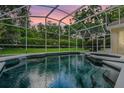 A sparkling screened in pool with a spa, beautiful landscaping and privacy at 871 Paddington Ter, Lake Mary, FL 32746
