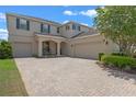 Inviting two-story home showcasing a brick driveway and well-maintained landscaping, with a two-car and one-car garage at 9025 Horizon Pointe Trl, Windermere, FL 34786