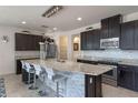 The kitchen features a spacious island with bar seating, stainless steel appliances, and stylish dark wood cabinets at 9025 Horizon Pointe Trl, Windermere, FL 34786