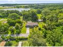 Expansive aerial view of a home surrounded by lush greenery, including a nearby lake at 1008 Bay Ave, Lake Wales, FL 33859