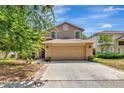 Charming two-story home with a stone-accented front, a two-car garage, and a well-manicured lawn at 1039 Eagles Forrest Dr, Apopka, FL 32712