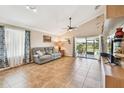 Inviting living room featuring tile floors, a ceiling fan, and sliding glass doors to the patio at 145 Lakeside Cir, Sanford, FL 32773