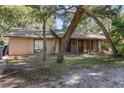 Single-story home with covered porch, screen door, mature landscaping, and large trees at 241 Ruth Blvd, Longwood, FL 32750