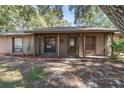 Single-story home with covered porch, screen door, mature landscaping, and large trees at 241 Ruth Blvd, Longwood, FL 32750