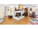 Cozy living room features a white brick fireplace and hardwood floors at 2678 Wilmhurst Rd, Deland, FL 32720