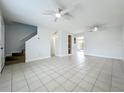 Bright living room featuring tile floors, two ceiling fans, and staircase access to upper level at 3247 Forest Oaks Ct # 116, Winter Park, FL 32792