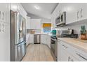 A bright kitchen features white cabinetry, stainless appliances and modern finishes at 3256 Amber St, Deltona, FL 32738