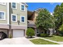 Townhome exterior with attached garage and a tree with vibrant pink blossoms at 3280 Soho St # 306, Orlando, FL 32835