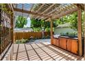 Backyard outdoor kitchen featuring a built-in grill and wooden pergola for shade at 336 E Kaley St, Orlando, FL 32806