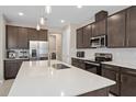 Modern kitchen with stainless steel appliances, a center island, and dark wood cabinetry at 3990 Bannock Ave, Tavares, FL 32778