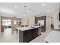Open kitchen with stainless steel appliances, large island, and adjacent dining area at 3990 Bannock Ave, Tavares, FL 32778