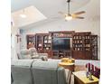 Comfortable living room with large entertainment center, ceiling fan, and cozy seating arrangement at 4471 Treasure Cay Rd, Tavares, FL 32778