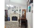 Cozy living area featuring a fireplace, neutral carpet, and stylish decor for a welcoming atmosphere at 4471 Treasure Cay Rd, Tavares, FL 32778