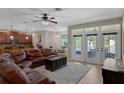 Spacious living room open to kitchen and eat in area with large sofa, white rug and access to patio at 480 Buckhorn Dr, Winter Springs, FL 32708