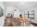 Dining room with modern chairs, wood floors, natural light, and view of the living room at 4940 Tennessee Lake Dr, Auburndale, FL 33823