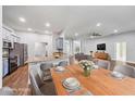 Open-concept kitchen and dining area featuring a granite countertop bar, stainless steel appliances, and wood floors at 4940 Tennessee Lake Dr, Auburndale, FL 33823