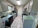 Traditional galley kitchen featuring gray cabinets, stainless appliances, and a gray backsplash at 56 Redwood Rd, Ocala, FL 34472
