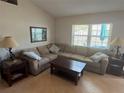 Cozy living room featuring a large sectional sofa, hardwood floors, and a large window at 56 Redwood Rd, Ocala, FL 34472