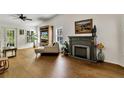 Comfortable living room features a modern fireplace, wood floors, plantation shutters, and ample natural light at 561 Vineyard Way, Poinciana, FL 34759