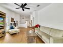 Spacious living room with vaulted ceilings, wood floors, neutral decor, and a ceiling fan at 561 Vineyard Way, Poinciana, FL 34759