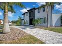View of a modern two-story home with manicured lawn, palm trees, and a patterned driveway at 5708 Emerington Cres, Orlando, FL 32819