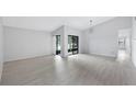 Bright open-concept living room with sliding glass doors, high ceilings, and modern lighting at 7237 Woodville Cres, Orlando, FL 32819