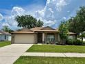 Inviting home with a manicured lawn, front garden beds, and a two-car garage at 734 La Costa St, Minneola, FL 34715