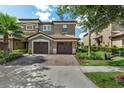 Charming townhome with brick paver driveway, two-car garage, and well-manicured landscaping at 8970 Azalea Sands Ln # 2302, Davenport, FL 33896