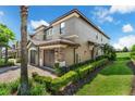 Side view of the townhome showcasing its well-maintained yard and stucco exterior at 8970 Azalea Sands Ln # 2302, Davenport, FL 33896