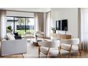 Bright, modern living room with large windows, neutral tones, and stylish decor at 917 Lake Emerald Dr, Orlando, FL 32806