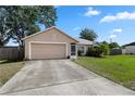Inviting single-story home with an attached garage and a well-manicured lawn at 144 Fort Smith Blvd, Deltona, FL 32738