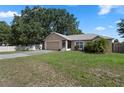 Quaint single-story home with an attached garage and a lush, green lawn at 144 Fort Smith Blvd, Deltona, FL 32738
