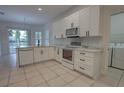Modern kitchen featuring white cabinets, stainless steel appliances, and tile flooring at 1679 Shadowmoss Cir, Lake Mary, FL 32746