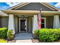 Inviting covered porch with white columns, manicured bushes, and black front door at 2781 Sand Oak Loop, Apopka, FL 32712