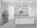 A bright kitchen features gray cabinets, granite countertops, stainless steel appliances, and a spacious center island at 3984 Mayhill Loop, Eustis, FL 32736