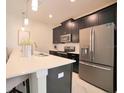 Modern kitchen with stainless steel appliances, granite countertops, and dark wood cabinetry at 4973 Windermere Ave, Kissimmee, FL 34746